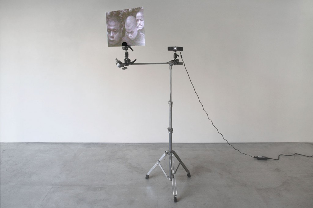 Ken Matsukaba, akuhatsu Heads - Microphone Stand ￼h156 × w82 × d34 cm film, pied de microphone, projecteur, planche d’acrylique, médias mixes, courtesy galerie Eric Mouchet.